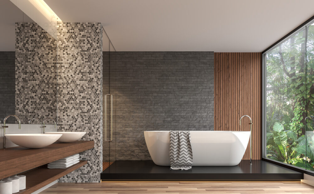 Modern contemporary bathroom 3d render. There are gray nature stone brick wall, wood floor.The room has large windows. Looking out to see the garden view.