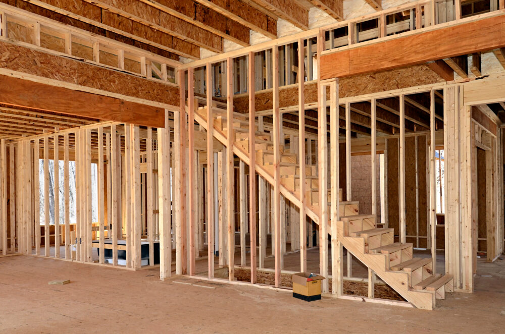 The interior of a home under construction showing the stairs, bedroom or office and bath areas.